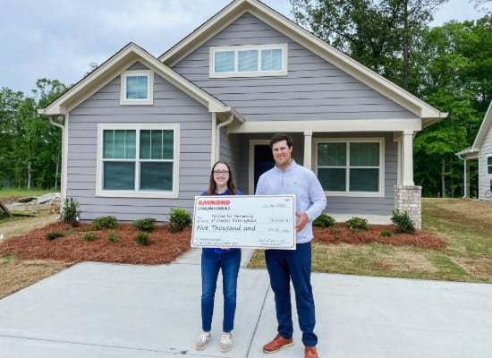 Carolina Handling associate Zach Neff presents a $5,000 check to Habitat for Humanity of Greater Birmingham 