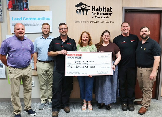 Carolina Handling associates present a $5,000 check to Habitat for Humanity of Wake County.