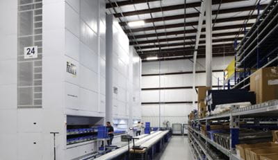 Modula VLM in a warehouse with workers picking items from Modula unit.