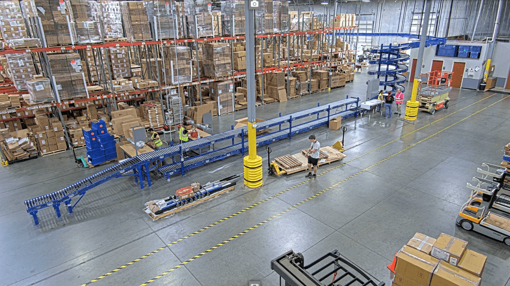 A new conveyor takes orders from packing stations to an MDR spiral turn which lifts them to an overhead conveyor and delivers them across the warehouse to shipping.