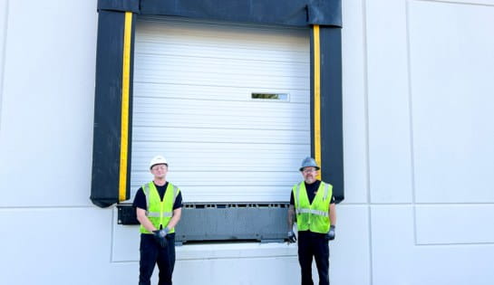 two techs outside a warehouse dock door