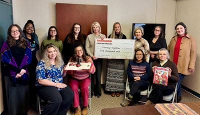 Carolina Handling presents check to Literacy Together staff